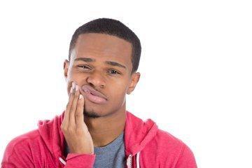 Man holding jaw from emergency dental pain