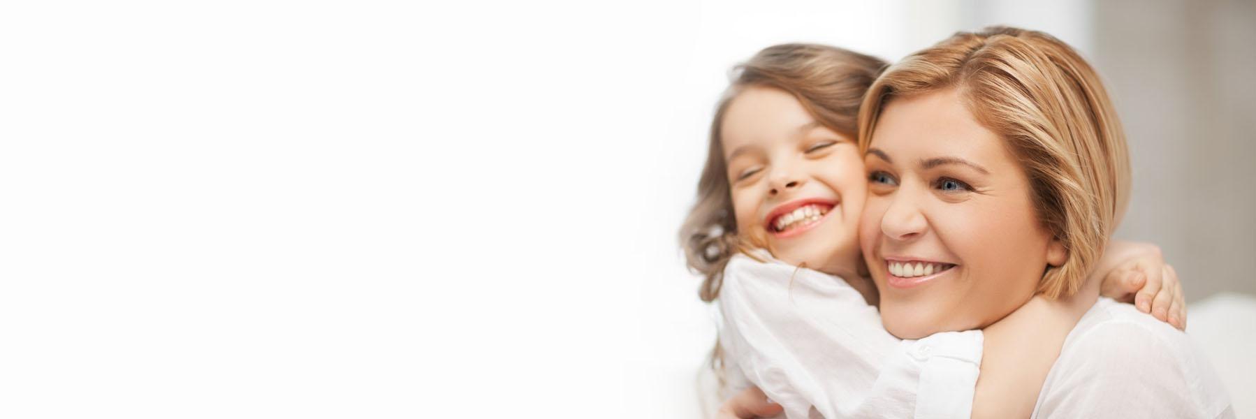 Young daughter hugging her mom and smiling